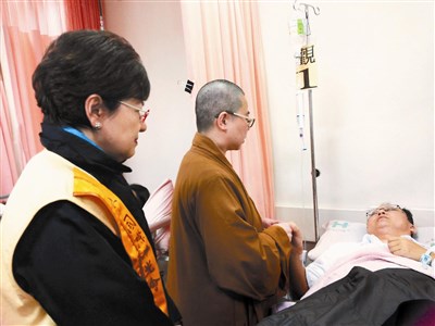 北區執行長朱唐妹（左）在復航墜河後，與台北道場知貫法師（中）到醫院探視飽受驚嚇的計程車司機。