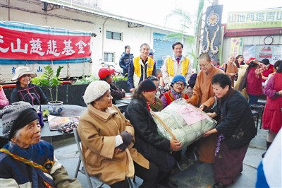 慈悲基金會南區執行長蕭碧涼（右一）、旗山禪淨中心住持覺藏法師（右二）送愛到青山社區。