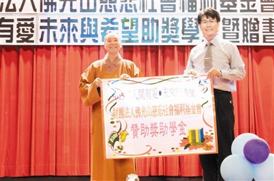 慈善院院長依來法師（左）代表慈善院頒發獎助學金，明陽中學校長陳宏義（右）代表接受。